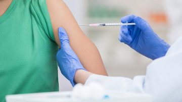 Healthcare professional gives girl a flu vaccine.